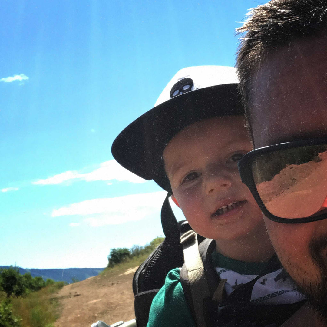 Milk x Whiskey - A father and son looking at the camera while out on a trail adventuring in the outdoors.