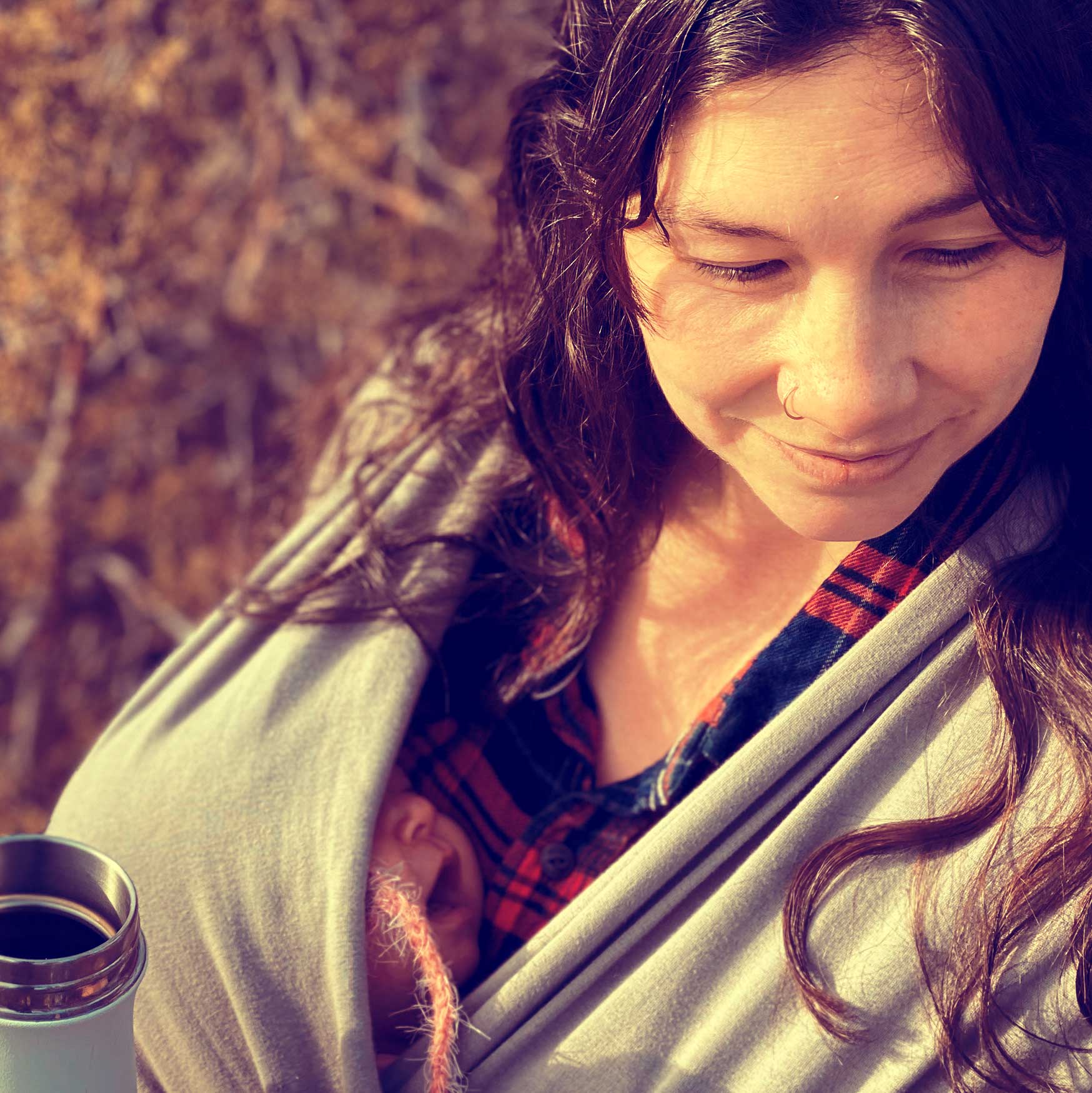 Milk x Whiskey - A mother with her new born outdoors wrapped in a comfortable shaw while drinking coffee. Wearing our flannel.