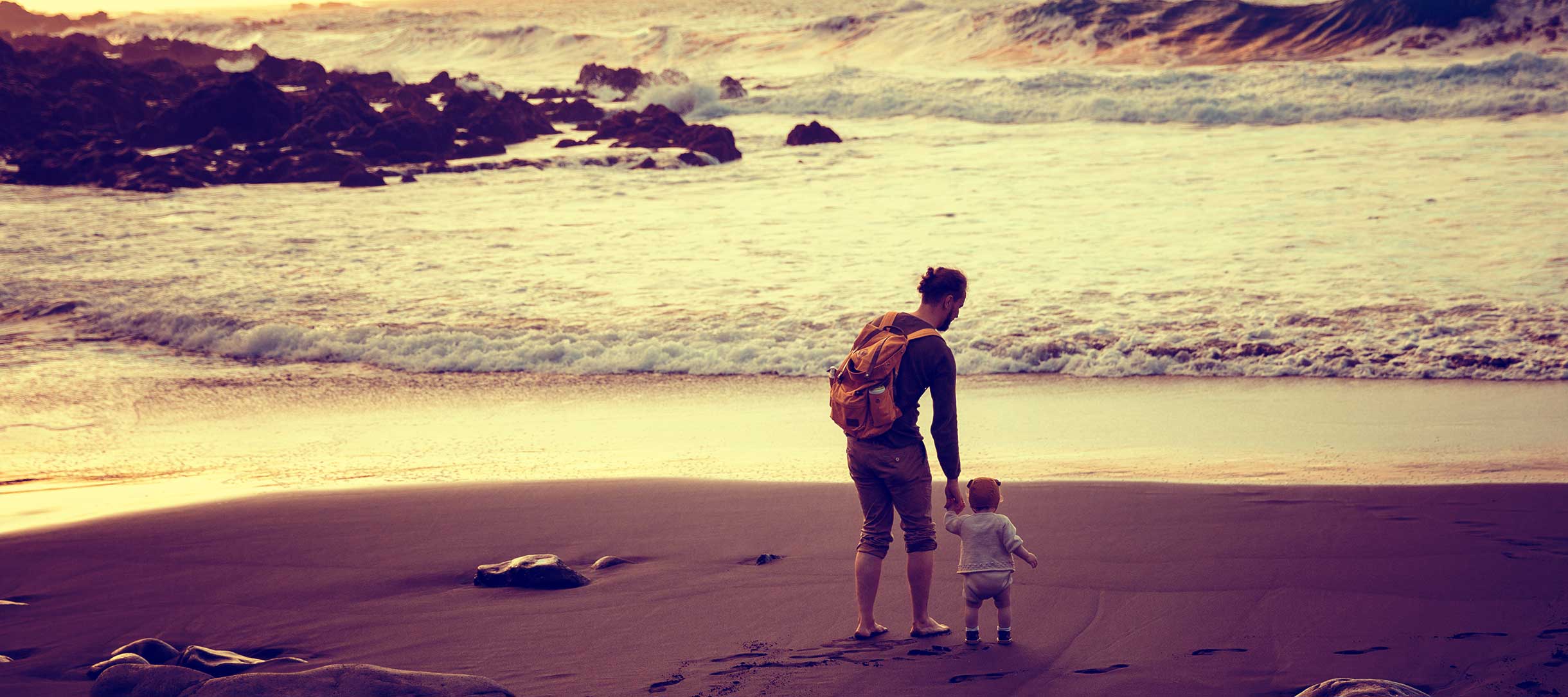 Milk x Whiskey - Sunset on the beach. A father and their child on the shore while the father is showing their baby a new discovery.