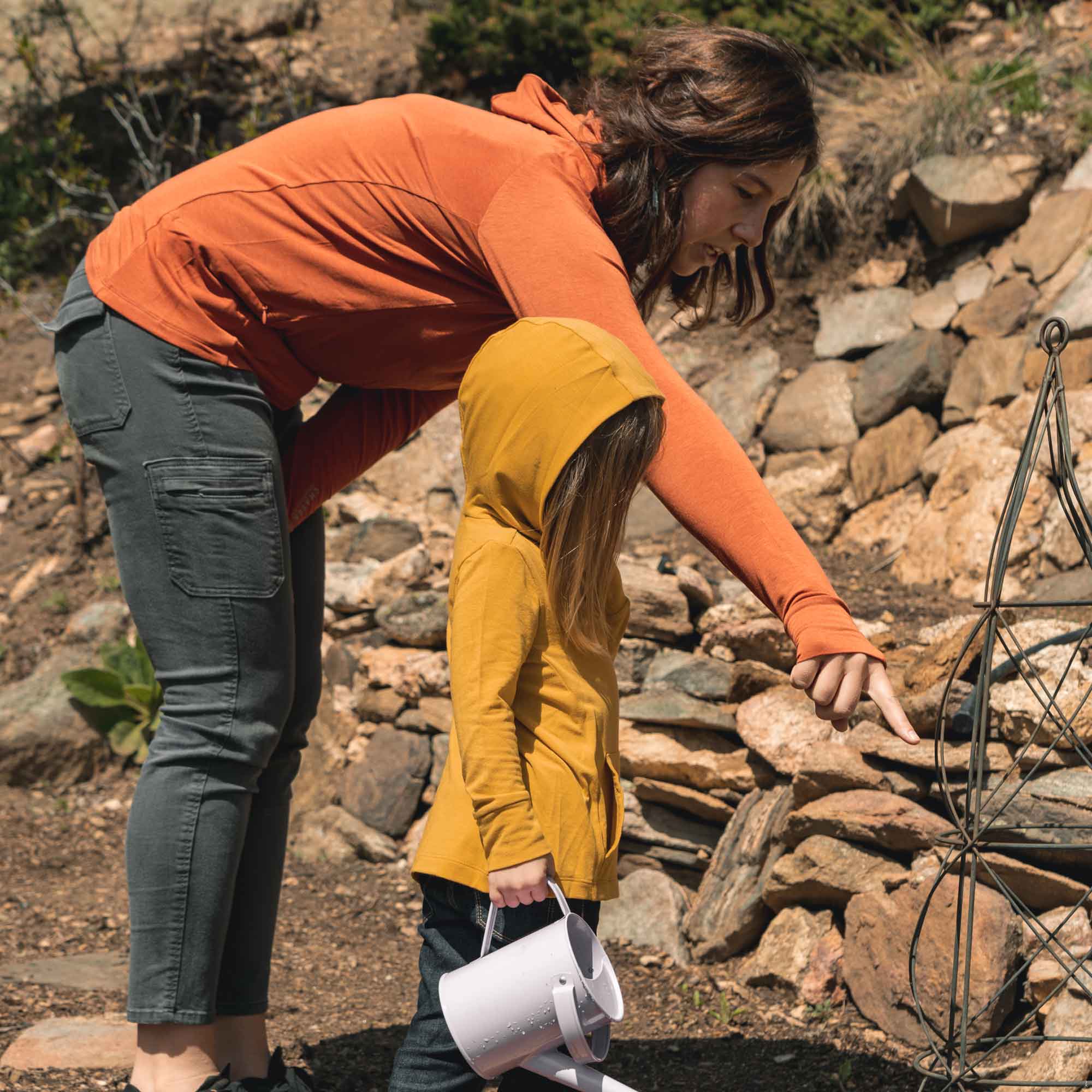 Child wearing CHASER Toddler Sun Hoodie with UPF50+ playing outdoors with parent, showcasing sun protection and eco-friendly design.